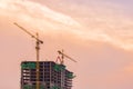 Industrial construction cranes and building before sunrise.Industrial construction crane over building site Royalty Free Stock Photo