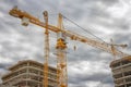 Industrial construction of new buildings. Crane on construction site near concrete buildings. Royalty Free Stock Photo