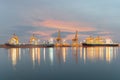 Industrial Container Cargo freight ship with working crane bridge in shipyard at dusk for Logistic Import Export background Royalty Free Stock Photo