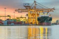 Industrial Container Cargo freight ship with working crane bridge in shipyard at dusk for Logistic Import Export background Royalty Free Stock Photo