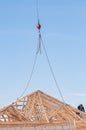 Industrial crane cable, red weight, hooks and chains, holding roof truss in place