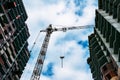 Industrial crane on construction site of new modern residential building at blue sky background Royalty Free Stock Photo