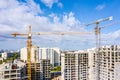 Industrial cranes at construction site against blue sky background. development of new residential area Royalty Free Stock Photo