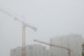Industrial cranes in fog Royalty Free Stock Photo