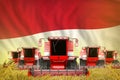 A lot of red farming combine harvesters on farm field with Indonesia flag background - front view, stop starving concept -