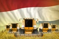 Industrial 3D illustration of some yellow farming combine harvesters on rye field with Netherlands flag background - front view,