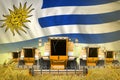 industrial 3D illustration of some yellow farming combine harvesters on wheat field with Uruguay flag background - front view,