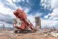 An industrial demolition machine tears through a building, symbolizing urban redevelopment and construction progress amidst Royalty Free Stock Photo