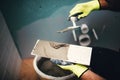 industrial detail of worker adding cement adhesive on small ceramic tiles