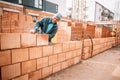 Construction bricklayer worker smiling and building walls with bricks, mortar and rubber hammer Royalty Free Stock Photo