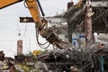 Industrial dismantle, mechanical destruction. Dismantling of the building with the help of heavy hydraulic shears.