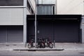 Industrial district with grey warehouse, empty wall space for design layout and bicycle parking on the street.