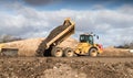 Industrial dumper truck moving tipping earth on a construction site