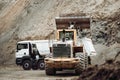 Industrial dumper trucks and wheel loader working on construction site, loading and unloading gravel and earth. heavy duty machine Royalty Free Stock Photo