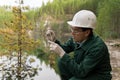 Industrial ecologist takes a sample of water from a flooded quarry