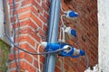 Industrial electrical outlets and cables mounted on a red brick wall outdoors Royalty Free Stock Photo