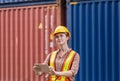 Industrial engineer in hard hat containers box background, Dock worker holding tablet smartphone at containers cargo, Logistic and Royalty Free Stock Photo