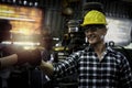Industrial engineer wearing helmet and safe glasses, worker fist bump knuckle bump during operating with machinery at