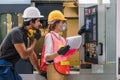 Industrial or factory engineering worker and supervisor setting up computerized control panel of factory assembly line controller Royalty Free Stock Photo