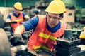 The industrial factory inspector wearing safety helmet and goggle watching on measurement tools on factory machine equipments to