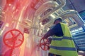 Industrial factory worker turning red wheel valve