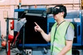 Industrial factory worker wearing VR goggle touching in virtual reality world inside factory