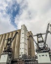 Industrial Grain Silos and Loading Cranes Under Cloudy Sky Royalty Free Stock Photo
