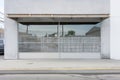 industrial gray steel mesh overlaying a white concrete storefront