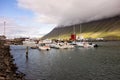 The industrial harbour of the Isafjordur city in Iceland with a yachts, boats and mountain covered in foggy clouds