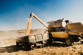 Industrial harvester unloading corn crops into tractor trailer