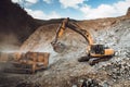 Industrial heavy duty excavator moving gravel on highway construction site