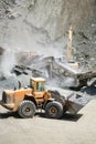 Industrial heavy duty large wheel loader moving gravel on highway construction site Royalty Free Stock Photo