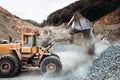 Industrial heavy duty wheel loader moving gravel on construction site.