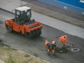 Industrial heavy roller for leveling and rolling the surface of hot asphalt, work on laying asphalt in urban