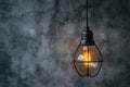 Industrial innovation hanging lightbulb on textured cement backdrop