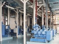 An industrial interior featuring large blue machinery and complex piping systems. Royalty Free Stock Photo