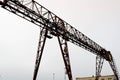 Industrial iron large metal gantry crane with a hook mounted on the supports for lifting and carrying heavy cargo Royalty Free Stock Photo