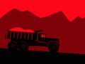 Industrial landscape. Big black dump truck against the background of red mountains and alarming red sky.