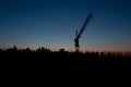 Industrial landscape. Construction cranes and concrete structure at silhouettes sunset. Royalty Free Stock Photo