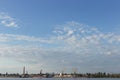 Industrial landscape, cranes, ships and factories on the river bank, against the blue sky Royalty Free Stock Photo