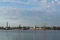 Industrial landscape, cranes, ships and factories on the river bank, against the blue sky Royalty Free Stock Photo