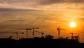 Industrial landscape with silhouettes of cranes on the sunset. Royalty Free Stock Photo