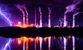 Industrial landscape with smoking chimneys and reflection in water at night