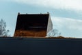 Industrial loader unloads sand with a bucket into a truck