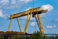 Industrial logging crane dwarfs log pile Royalty Free Stock Photo