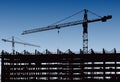 Industrial machinery and the construction crane. Cranes and skyscraper under construction, city skyline at sunset, sunrise Buildin Royalty Free Stock Photo