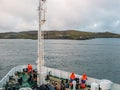 Industrial marine ship with workers in orange work ware, view from vessel deck