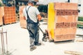 Industrial mason worker, construction worker transporting bricks on construction site Royalty Free Stock Photo