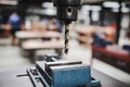 Industrial metal drill head in the workshop room with blurred background of students working on other workshop projects. Royalty Free Stock Photo