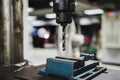 Industrial metal drill head in the workshop room with blurred background of students working on other workshop projects. Royalty Free Stock Photo